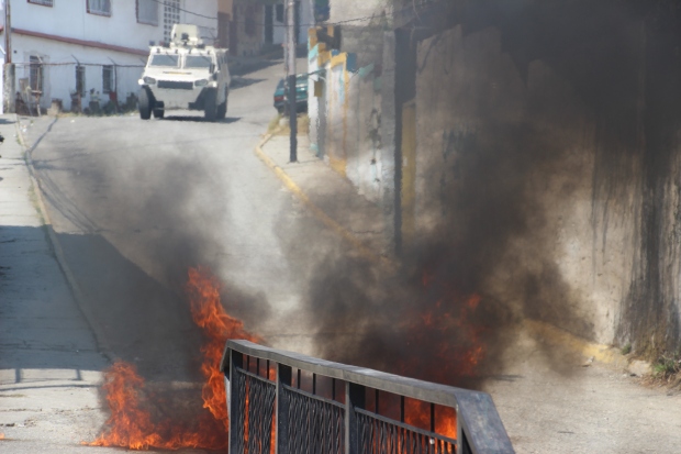 Opposition groups dumped fuel on the road, and set it alight. Here, the guard can be seen in the background searching Santa Anita's streets for attackers.